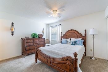 A bedroom with a large bed and a dresser